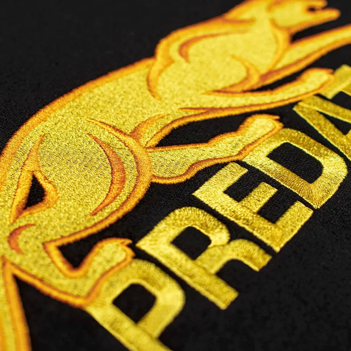 Close-up of gold embroidered Predator details
